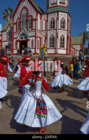 Members of a Pueblo dance group in ornate costumes performing at the annual Carnaval Andino con la Fuerza del Sol in Arica, Chile. Stock Photo