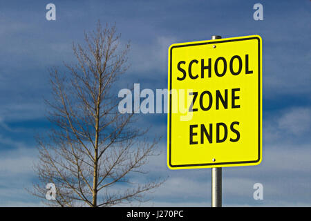 School Zone Ends Sign Against Sky Background With Tree Stock Photo