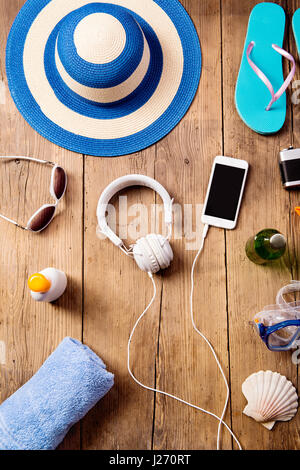 Summer vacation composition. Hat, earphones, smartphone. Stock Photo