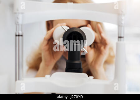 Focused professional ophthalmologist examining patients eyesight Stock Photo