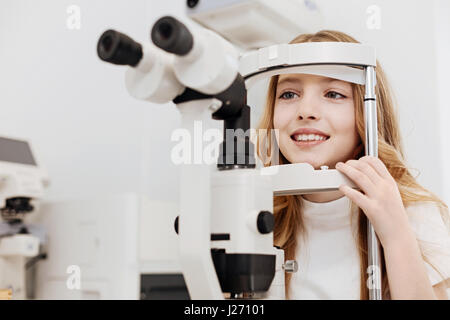 Bright beautiful girl curious about opthalmometer Stock Photo