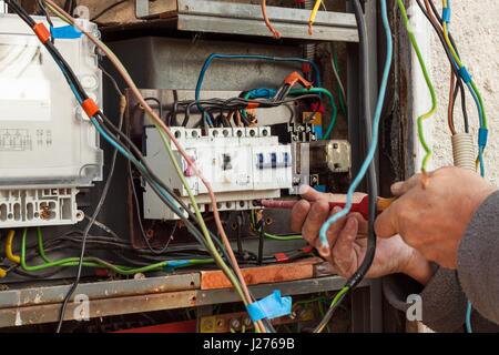Repair of old electrical switchgear. An electrician replaces old electrical wiring devices Stock Photo