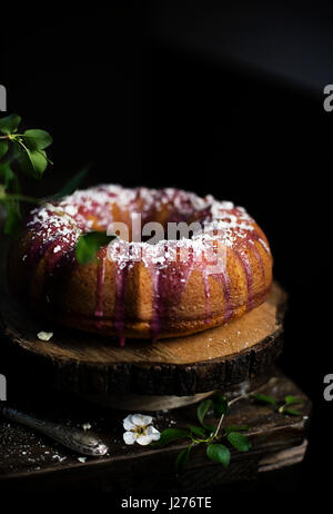 Bundt cake with blackberry glaze and white chocolate flakes Stock Photo