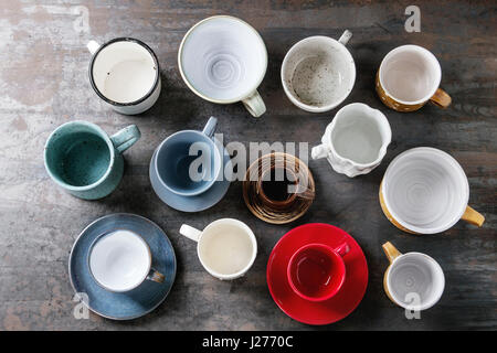Empty colorful modern ceramic plates and bowls collection. Various of dishware over dark metal background. Top view Stock Photo