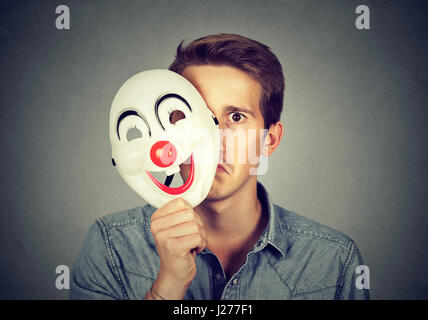 Man hiding behind a happy mask Stock Photo - Alamy