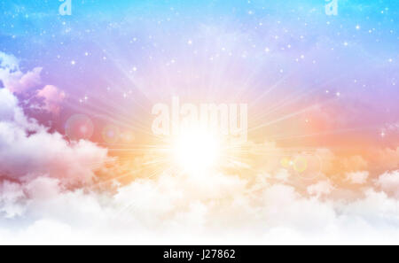 Early morning sky with the sun breaking through white clouds, stars shining behind. Stock Photo