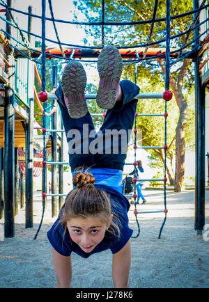 Young girl on a playground upside down Stock Photo