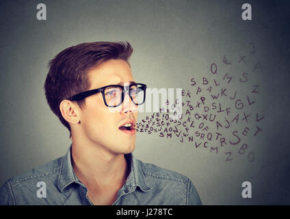 Side profile man talking with alphabet letters coming out of his mouth. Communication, information, intelligence concept Stock Photo