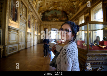 Young woman tourist is visiting the Apollo Gallery at the Louvre museum in Paris, France. Stock Photo