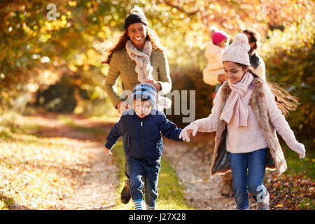 Family Running Along Path Through Autumn Countryside Stock Photo