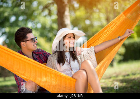 Young charming woman showing something in nature to her boyfriend Stock Photo