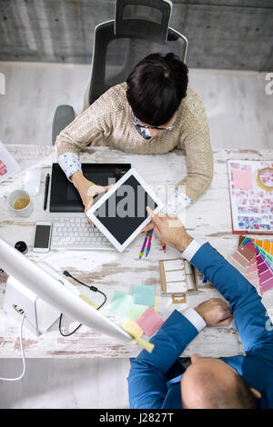 client showing color samples on tablet Stock Photo