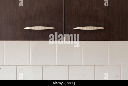 Closeup view on kitchen furniture, simple composition showing wooden and tiled parts. Stock Photo