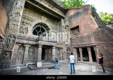 Tourists admire and take photos of one of the largest cave entrances at Ajanta Caves, Aurangabad, Maharashtra, India Stock Photo