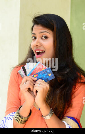 Happy excited amazed young woman holding credit cards Stock Photo