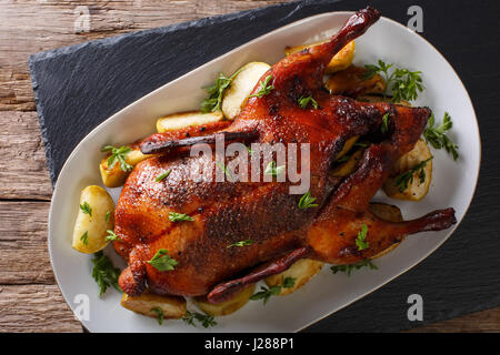 Delicious whole baked duck with apples close-up on a platter on the table. horizontal view from above Stock Photo