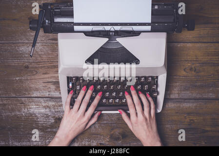 Female hands writing on an old typewriter Stock Photo