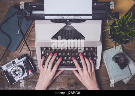 Female hands writing on an old typewriter Stock Photo