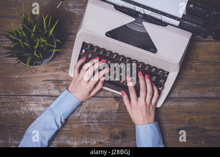 Female hands writing on an old typewriter Stock Photo