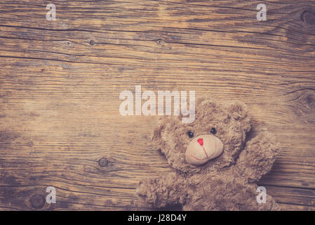 Brown teddy bear over wooden background Stock Photo