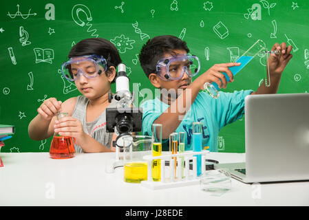 cute indian kids doing science experiment in chemistry lab or biology lab in school Stock Photo