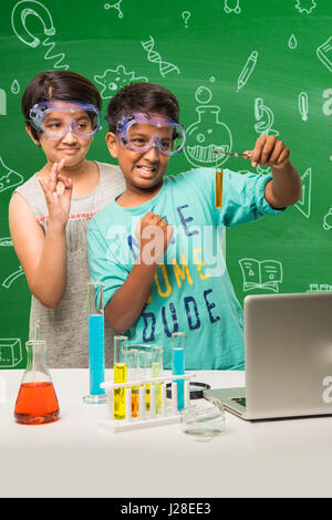 cute indian kids doing science experiment in chemistry lab or biology lab in school Stock Photo