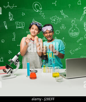 cute indian kids doing science experiment in chemistry lab or biology lab in school Stock Photo