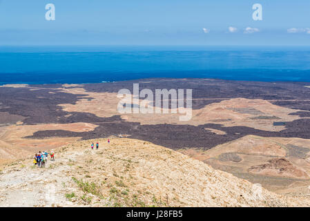 Group of hikers on Caldera Blanca, old volcano in Lanzarote, Canary islands, Spain Stock Photo