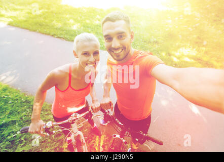 couple with bicycle taking selfie outdoors Stock Photo