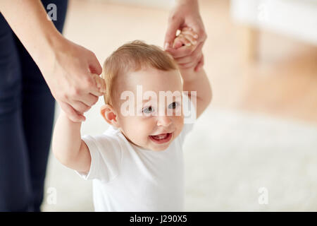 happy baby learning to walk with mother help Stock Photo
