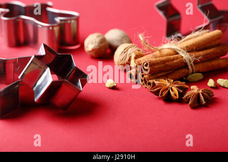 Red christmas background with cookies cutters, food closeup Stock Photo