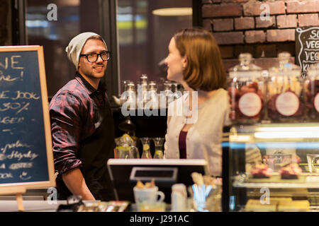 happy bartenders at cafe or coffee shop counter Stock Photo