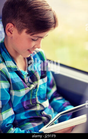 happy boy with tablet pc in travel bus or train Stock Photo