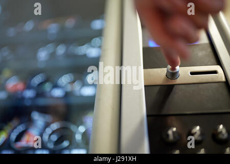 hand pushing button on vending machine Stock Photo