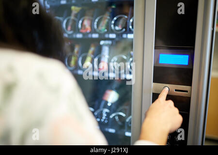 woman pushing button on vending machine Stock Photo