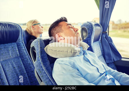 man sleeping in travel bus with cervical pillow Stock Photo