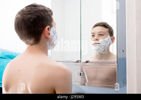 Young teenage boy shaving for the first time Stock Photo