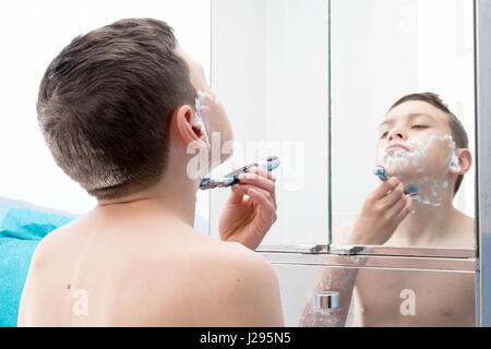 Young teenage boy shaving for the first time Stock Photo