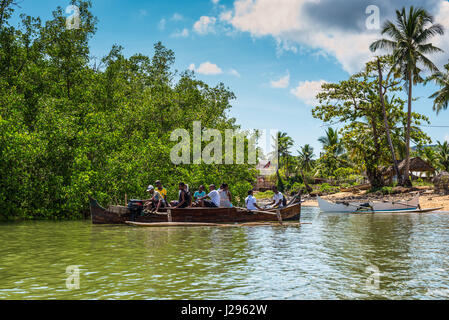Ambatozavavy, Nosy Be, Madagascar - December 19, 2015: Locals on the traditional wood pirogue with outrigger on the shore of the fishing village on th Stock Photo
