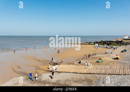 Holidaymakers enjoy spring sunshine on the beach at Sheringham Norfolk UK Stock Photo