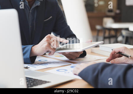 Businessman discussing with financial analyst business development strategy project chart document and using modern digital tablet touchpad Stock Photo