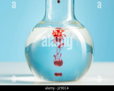 The laboratory glassware and red liquid inside on white Stock Photo