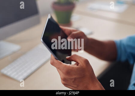 Designer sitting at his office desk using a tablet Stock Photo