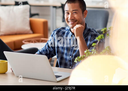 Content Asian designer at work in a modern office Stock Photo