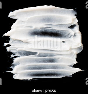 Structural plaster white on a black background. White Cream. paint smear. Stock Photo