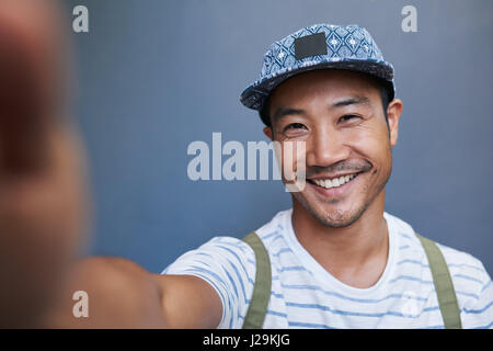 Stylish young Asian man taking a selfie outside Stock Photo