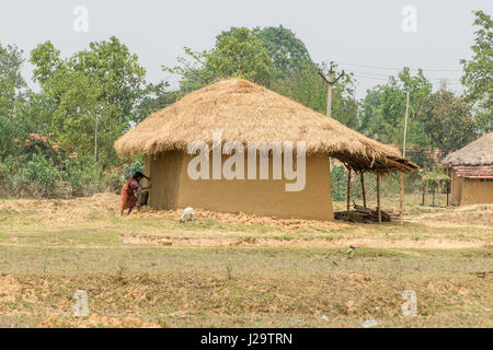 Bankura, West bengal,India.April 22, 2017. An unidentified village woman is working outside her mud house. Stock Photo