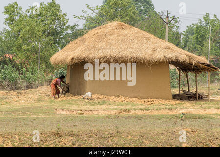 Bankura, West bengal,India.April 22, 2017. An unidentified village woman is working outside her mud house. Stock Photo