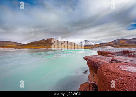 Chile lagoon called “Red Rocks” nearby San Pedro de Atacama is situated in an area deep in the desert, less than 30 kilometres from the Bolivian border at almost 4.400 mt slm. Stock Photo