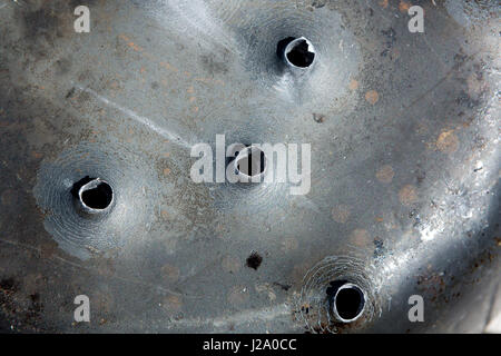 Macro shot of bullet holes after a target shooting in a aluminum pan. Stock Photo